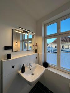 a white bathroom with a sink and a window at Apartmenthaus Buxtehude St -Petri-Platz Apt 4 in Buxtehude