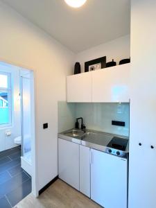 a kitchen with white cabinets and a sink at Apartmenthaus Buxtehude St -Petri-Platz Apt 4 in Buxtehude