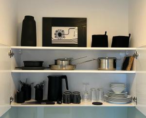 a shelf with pots and pans and other kitchen items at Apartmenthaus Buxtehude St -Petri-Platz Apt 4 in Buxtehude