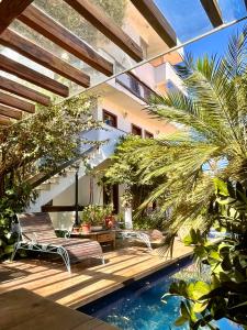 a patio with two chairs and a table next to a pool at Hotel Vila Nova do Príncipe in Caetité