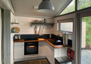 a kitchen with a sink and a stove at Isle of Wight Cabin in Newtown