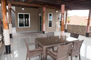 a wooden table and chairs on a patio at The Pearl Cottages in Kampala