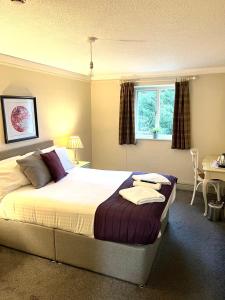 a bedroom with a bed and a table and a window at Slyne Lodge in Hest Bank