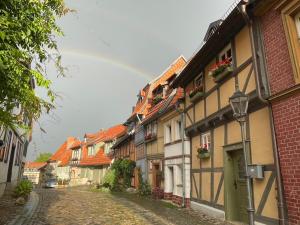 a street with buildings and a rainbow in the sky at Mittelalterdomizil mit Balkon und Parkplätzen in Quedlinburg