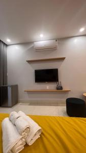 a room with a tv and a bed with towels at Ez mart and stay in Hai Phong
