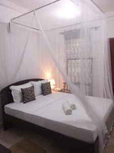 1 dormitorio con 1 cama con mosquitera en Kavee Transit Hotel en Katunayaka