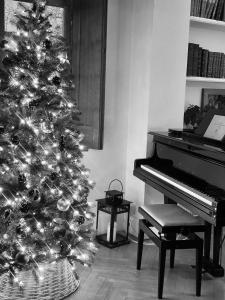 a christmas tree in a living room with a piano at Le Prieuré sur Seine in Marnay-sur-Seine