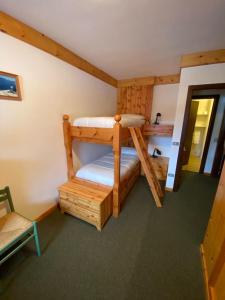 a room with two bunk beds in a cabin at Bilocale ad un passo dalle piste in Madonna di Campiglio