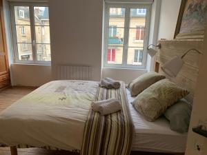 un letto in una camera con due cuscini sopra di Au coeur d'Argentan ad Argentan