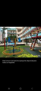 a playground with a slide in front of a building at Ap Vista Mar em Caraguatatuba in Caraguatatuba