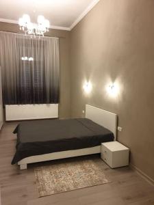a bedroom with a black bed and a window at Apartament ultracentral. in Arad +8 photos