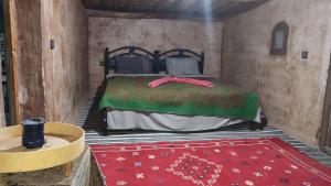 a small room with a bed and a red rug at Camp & Trek in Mhamid