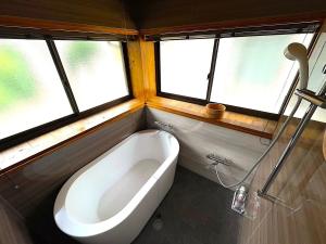 a bath tub in a bathroom with windows at pine mountain - Vacation STAY 48815v in Goto