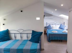 2 camas con almohadas azules en un dormitorio en La Casa dei Panorami di Colobraro, en Colobraro