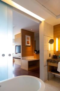 a bathroom with a tub and a television in a room at The Westin Chennai Velachery in Chennai