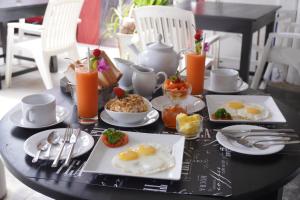 a black table with breakfast foods and drinks on it at SURF UNA BEACH HOTEL in Unawatuna