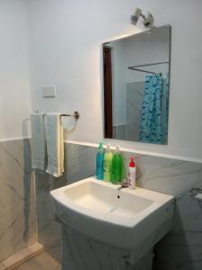 a bathroom with a white sink and a mirror at Kavee Transit Hotel in Katunayaka