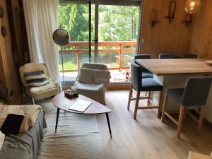 een woonkamer met een tafel en stoelen en een groot raam bij Appartement 6 personnes aux 2 Alpes, au pied des pistes - Wi-fi, Parking gratuit, Terrasse vue sur jardin in Les Deux Alpes