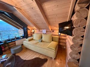uma sala de estar com um sofá e uma grande janela em Rönk Relax em Miskolc