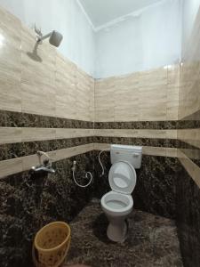 La salle de bains est pourvue d'une douche et de toilettes. dans l'établissement Bamboo garden, à Varkala