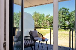 a screened porch with a chair and a table at FeWo Prora - Gooddays in Binz