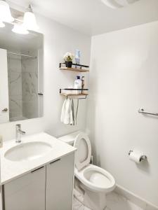 a white bathroom with a toilet and a sink at Toronto Downtown Midtown North York Newly Built Modern Bright Room in Toronto