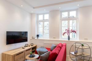 a living room with a red couch and a tv at Richter Altstadtappartements in Goslar