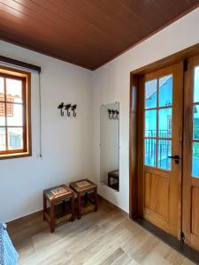 um quarto vazio com uma porta e duas mesas em Chalé Três - Casa de temporada em Tiradentes em Tiradentes