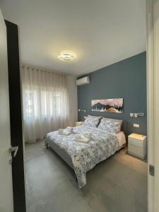 1 dormitorio con cama y pared azul en B&B Morelli Home, en Cosenza