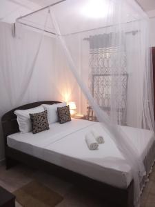 een slaapkamer met een bed met een klamboe bij Kavee Transit Hotel in Katunayaka