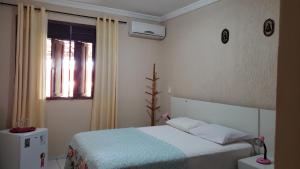 a small bedroom with a bed and a window at Casanostra44 in Genipabu +75 photos