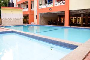 a large swimming pool in front of a building at Millan Homes in Mombasa