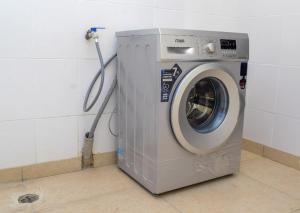 uma máquina de lavar roupa num canto de um quarto em Millan Homes em Mombasa