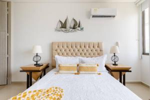 Sensacional apartamento en Samaria Club de Playa في سانتا مارتا: غرفة نوم بسرير كبير مع مواقف ليلتين