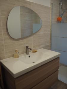 a bathroom with a white sink and a mirror at Le Cocon in Millau