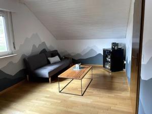 a living room with a couch and a coffee table at Herzliches Zimmer im Zürcher Oberland in Wald