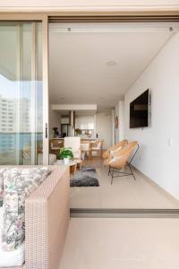 Sensacional apartamento en Samaria Club de Playa في سانتا مارتا: غرفة معيشة مع أريكة وغرفة طعام