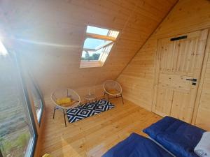 una camera con due sedie e un letto in una cabina di Świętokrzyskie Stodoły - Domek TUTOK a Psary Kąty