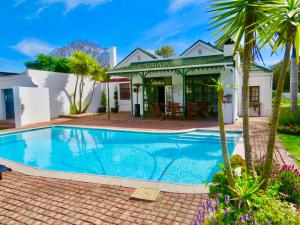 a swimming pool in front of a house at Whistlewood Guesthouse Walmer, Port Eizabeth in Port Elizabeth