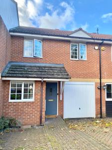 una casa de ladrillo rojo con garaje blanco en Stunning Home Driveway and Garden FREE PRIVATE PARKING - Northampton en Northampton