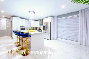 a kitchen with a bar with blue stools in it at Zenzola's gateway Near Downtown in Longueuil