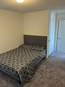 um quarto com uma cama com um edredão em Luxury Brand New Townhouse In Milton Ontario em Milton