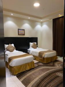 two beds in a hotel room withskirts at Kyan Abha Hotel - فندق كيان ابها in Abha