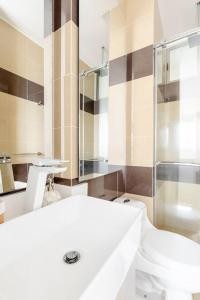 y baño con aseo y ducha acristalada. en Sensacional apartamento en Samaria Club de Playa, en Santa Marta