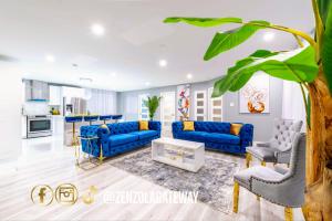 a living room with blue couches and a kitchen at Zenzola's gateway Near Downtown in Longueuil