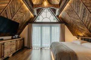 a bedroom with a bed and a large window at Domek na Wilczniku in Zakopane