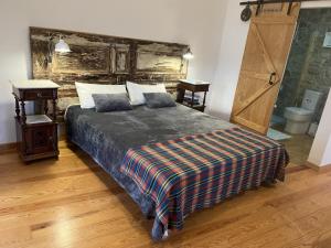 a bedroom with a large bed with a plaid blanket at Casa das Raposas in Zambujal