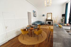 - un salon avec une table et des chaises jaunes dans l'établissement Appartement Sarlovèze - Stay in Sarlat, à Sarlat-la-Canéda