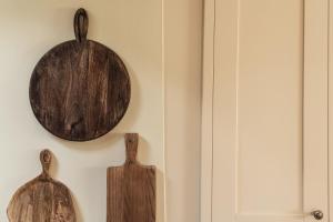 two wooden cutting boards hanging on a wall at Yew Tree: Historic Georgian Farmhouse, Ellonby in Ellonby