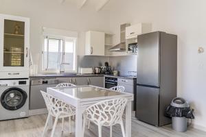 een keuken met een witte tafel en een koelkast bij Villa Swany in Petit-Bourg